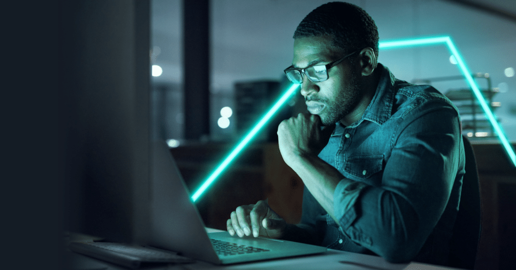Man wearing spectacles is focused on his laptop