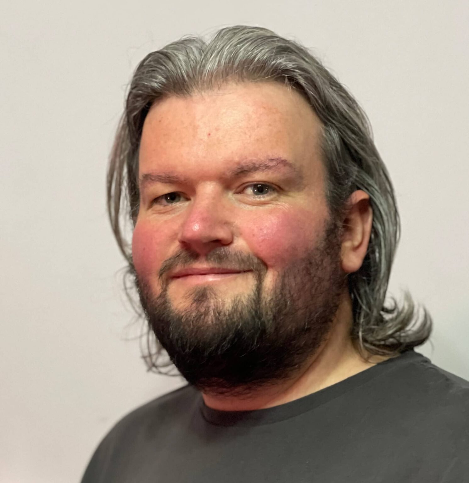 A headshot of a smiling map with a grey t-shirt