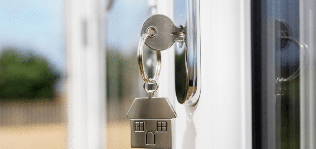 A silver key ring(with an attached house keychain) in the door
