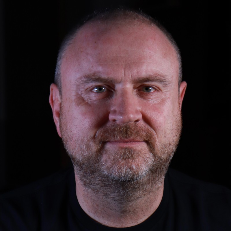 Portrait of a smiling man in black background